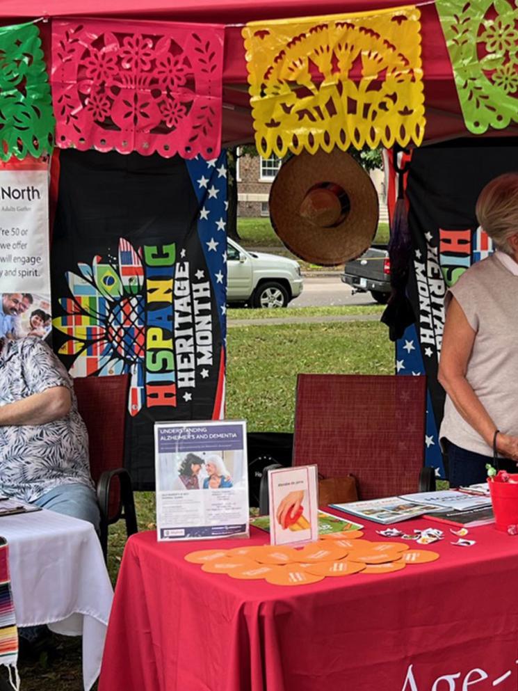Volunteer at booth during Hispanic Heritage celebration