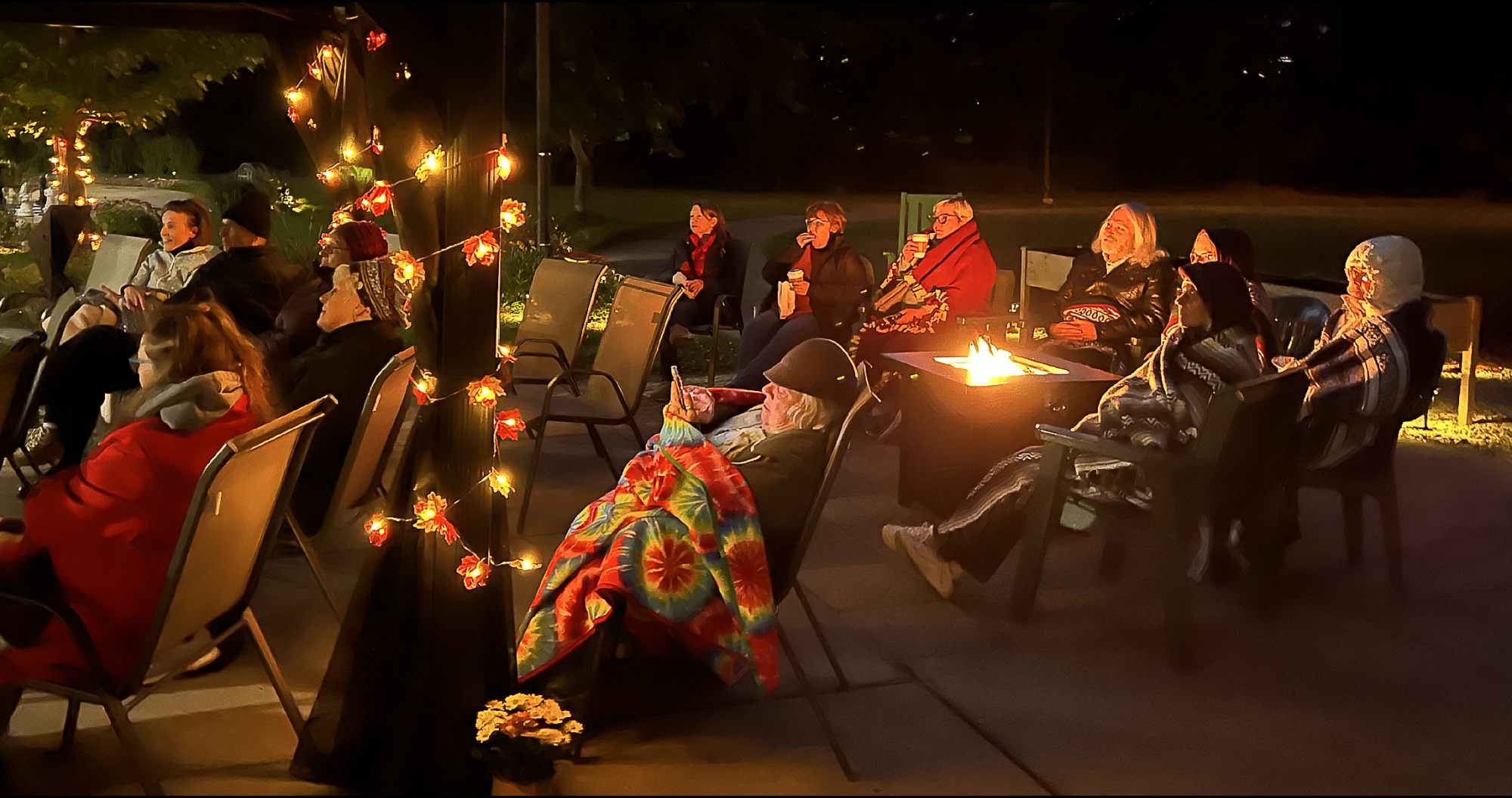 Members enjoy a summer evening in courtyard, after dark