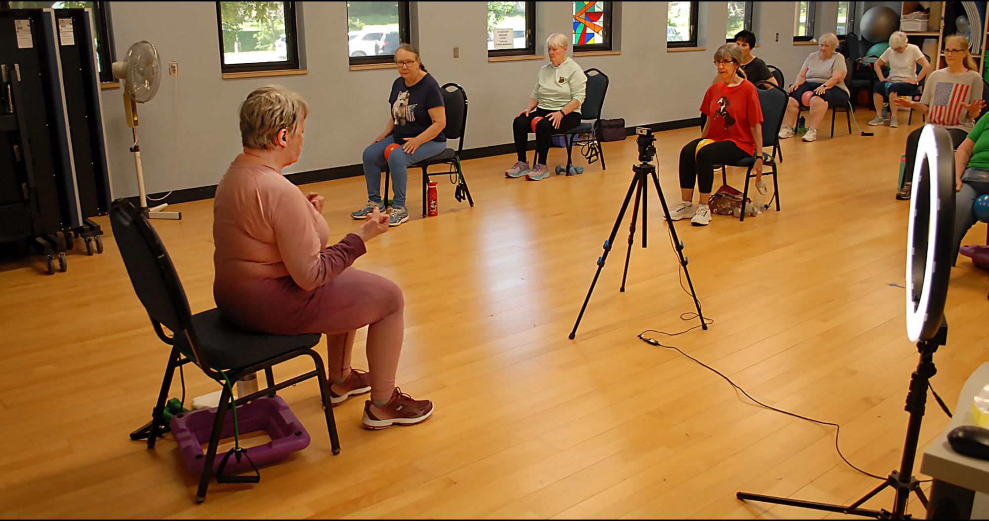 Sheila leading a Silver Sneakers exercise group, in person and online